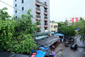 a busy city street with a tall building and people at Hotel Sai Inn in Mumbai