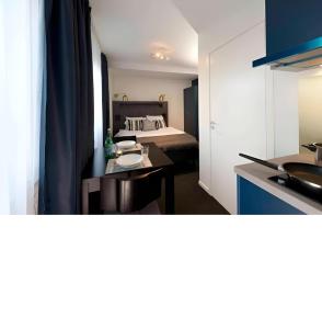 a kitchen and a bedroom with a bed and a table at Communia Hotel Residence in Stockholm