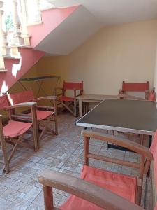 Cette chambre comprend une table de ping-pong et des chaises. dans l'établissement New Village apartment, à Chios