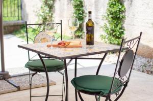 een tafel met een fles wijn en twee stoelen bij Dépendance 6 in Salerno