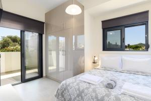 a bedroom with a large bed and large windows at Green Villa in Ialyssos