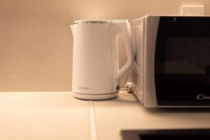 a white coffee cup next to a microwave at Lapidea apartments in Skradin