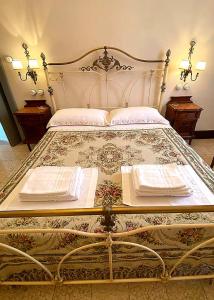 un letto con due tovaglioli sopra con due tavoli di Adeste 41 a Scicli