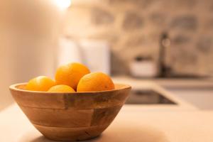 a wooden bowl of oranges sitting on a counter at Lapidea apartments in Skradin