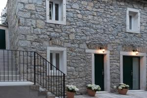 a stone building with stairs and flowers in pots at Lapidea apartments in Skradin