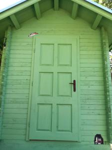a green door on the front of a house at Camping Curtea Pescărușului in Vama Veche