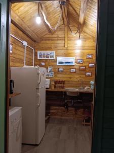 a kitchen with a refrigerator and a desk in it at Camping Curtea Pescărușului in Vama Veche