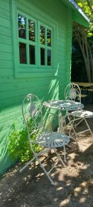 a table and chairs in front of a green house at Camping Curtea Pescărușului in Vama Veche