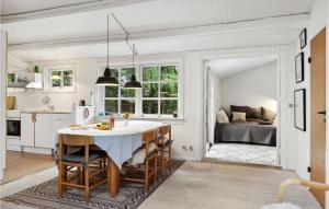 eine Küche mit einem Tisch und ein Wohnzimmer mit einem Bett in der Unterkunft Stunning Home In Frevejle With Wifi in Fårevejle