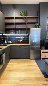 Il comprend une cuisine équipée d'un réfrigérateur en acier inoxydable. dans l'établissement The Artist Residence / 1 bedroom w/ Piano next to a Park, à Riga