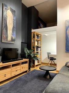 - un salon avec un canapé et une télévision dans l'établissement The Artist Residence / 1 bedroom w/ Piano next to a Park, à Riga