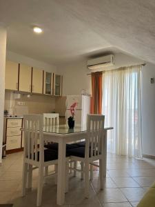 a kitchen with a dining room table and chairs at Apartmani Bekonja in Tivat