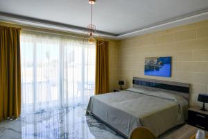 a bedroom with a bed and a large window at Azure W B&B in San Lawrenz