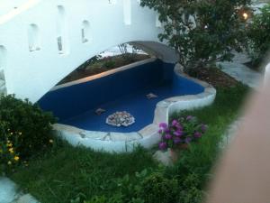 a garden with a blue floor and a bridge at Flora's Apartments in Apollon