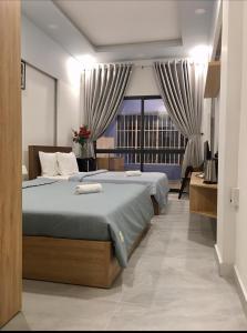 a bedroom with two beds and a large window at Saigon Cozy Home " At BuiVien Walking Street " - Self Check In in Ho Chi Minh City