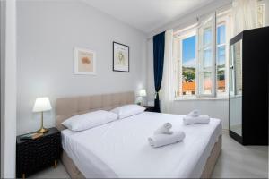 a bedroom with a large white bed with towels on it at The Bassegli - Gozze Palace in Dubrovnik