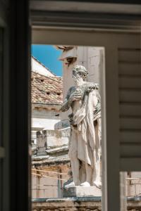 uma estátua de um homem ao lado de um edifício em The Bassegli - Gozze Palace em Dubrovnik