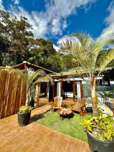 a backyard with a wooden deck with chairs and a table at Villa Pantai Secret Place in Miracatu