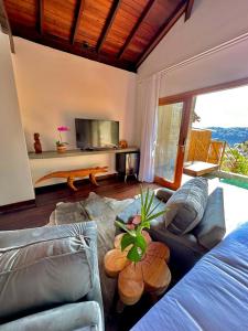 a living room with a couch and a table at Villa Pantai Secret Place in Miracatu +148 photos