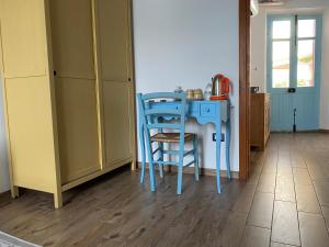 a kitchen with a blue table and chairs at B&B Alba Chiara in Oristano