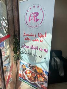 un cartel en la puerta de un restaurante con un cartel de comida en أبها ريجنسي, en Abha