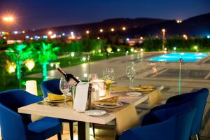 Miracle Istanbul Asia Airport Hotel & Spa في إسطنبول: طاولة مع زجاجة من النبيذ وكؤوس النبيذ
