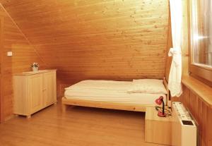 małą sypialnię z łóżkiem i drewnianą ścianą w obiekcie Chata Soňa w Tierchowej