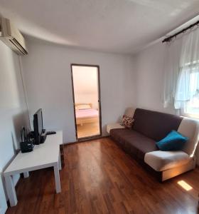 a living room with a couch and a mirror at Bella Vista Apartment in Podgorica