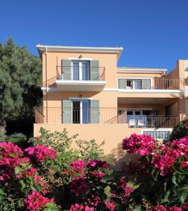 un edificio con flores rosas delante de él en Villa Melias, luxurious villa with superb view of the islands, 400 m from the sea, en Nydri