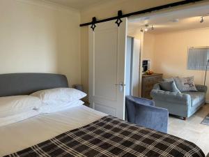 1 dormitorio con 1 cama, 1 sofá y 1 silla en One bedroom bungalow with private garden at Parkland, near Kingsbridge, en Kingsbridge