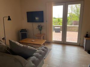 a living room with a couch and a table at One bedroom bungalow with private garden at Parkland, near Kingsbridge in Kingsbridge