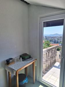 Habitación con mesa y puerta con ventana en Bella Vista Apartment en Podgorica