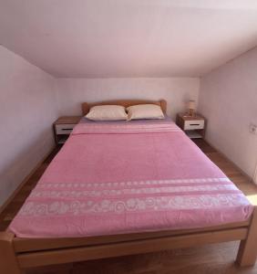 a bedroom with a large bed with a pink blanket at Bella Vista Apartment in Podgorica