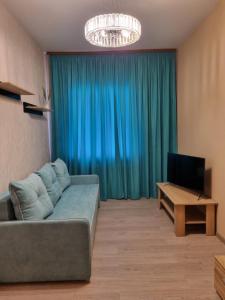 a living room with a couch and a television at Затишна однокімнатна квартира під Києвом in Kopylov