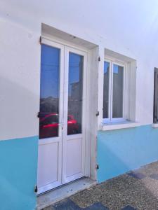 una puerta y ventanas blancas en un edificio blanco en Casa Monica , summer apartment, en Cargèse