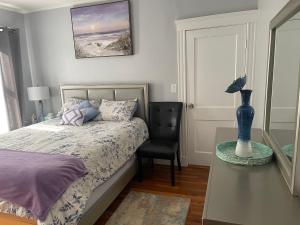 a bedroom with a bed and a table and a chair at Boston Luxury 2 Bedroom Private Condo in Boston