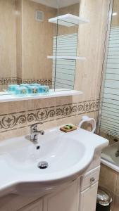 ein Badezimmer mit einem weißen Waschbecken und einem Spiegel in der Unterkunft Benalmarina Sea View Apartments in Benalmádena