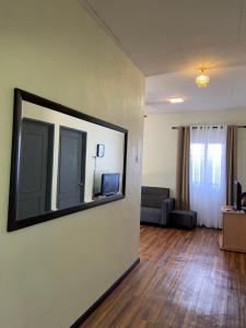 een woonkamer met een spiegel aan de muur bij Aisyah Homestay Arau in Arau
