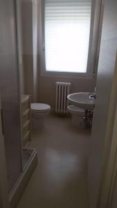 a bathroom with a toilet and a sink and a window at Appartamento in villetta a 2 passi dal mare e dal centro in Pesaro