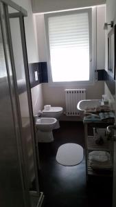 a bathroom with a sink and a toilet and a window at Appartamento in villetta a 2 passi dal mare e dal centro in Pesaro