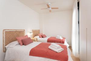 a bedroom with two beds with red and white sheets at Vivelorural Agaete 2D infinity pool & great views in Agaete +44 photos