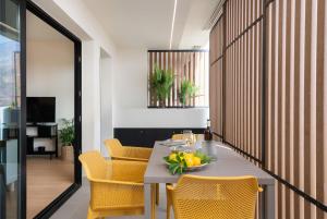 ein Esszimmer mit einem Tisch und gelben Stühlen in der Unterkunft Apartamento Roca Paraíso De Agaete Con Vistas Panorámicas in Agaete