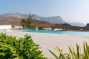 a swimming pool with mountains in the background at Vivelorural Agaete 2D infinity pool & great views in Agaete