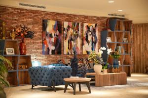 a living room with a blue couch and a brick wall at Les Regalia Hôtel & Spa in Sainte-Lucie de Porto-Vecchio