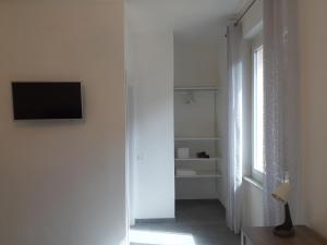 Habitación blanca con TV y ventana en Home, en Riomaggiore