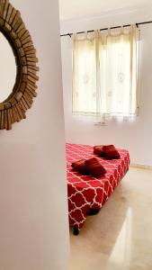 a red bed in a room with a window at Benalmarina Sea View Apartments in Benalmádena