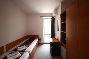 una piccola camera con due letti e una finestra di Fagaras a Eforie Nord