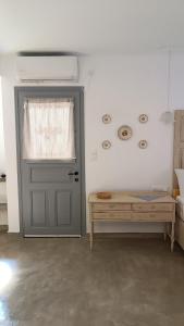 a door in a room with a bed and a table at Est 1852 - Cozy in Andros