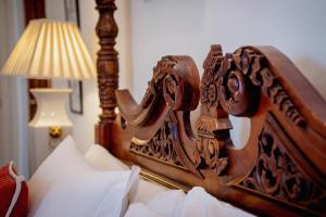 een houten hoofdeinde van een bed naast een lamp bij Hotel Boutique Casa Conde in Zafra