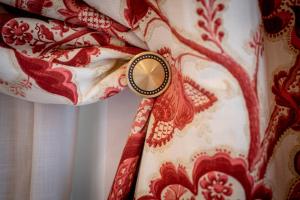 un reloj sobre una cortina roja y blanca en Hotel Boutique Casa Conde, en Zafra